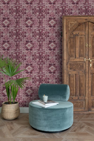 Dekoratives Wohnzimmer mit gemusterter Tapete, Sessel, Zimmerpflanze und Holztür