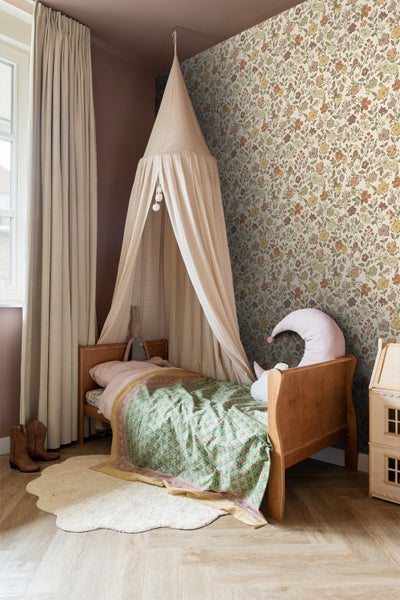 Gemütliches Kinderzimmer mit Bett, Baldachin und floraler Tapete