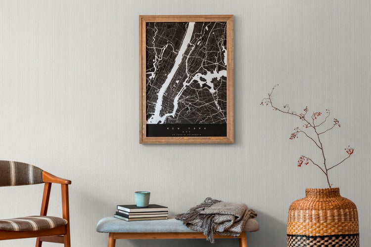 Dekorativer Wohnbereich mit Stuhl, Bank, Büchern, Decke, Vase und gerahmter New York Karte