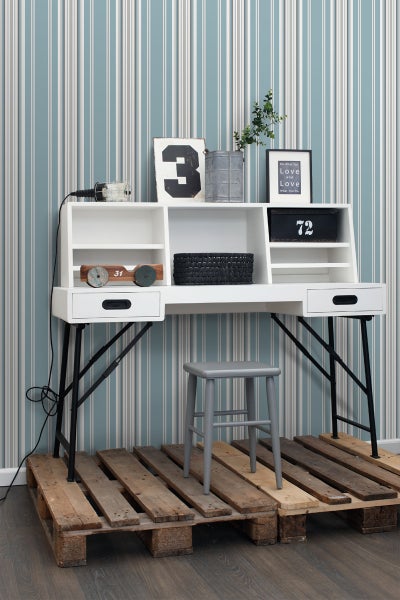 Schreibtisch mit Regalen, Schubladen und schwarzem Metallgestell auf einer Holzpalette, kombiniert mit einem grauen Hocker