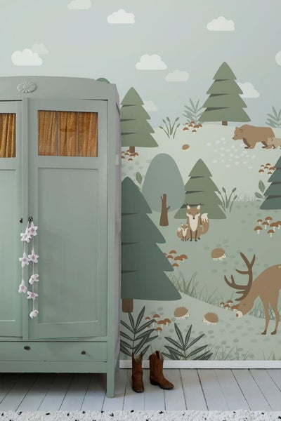 Dekoratives Kinderzimmer mit Waldtapete, Kleiderschrank und Stiefeln.