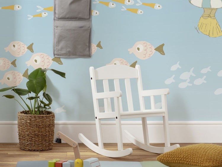 Kinderspielzimmer mit weißem Schaukelstuhl, Zimmerpflanze im Korb und Wanddeko mit Fischmotiven
