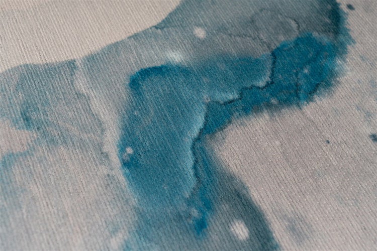 Nahaufnahme eines Teppichs mit Rippenstruktur und abstraktem blauem Muster im Aquarellstil.