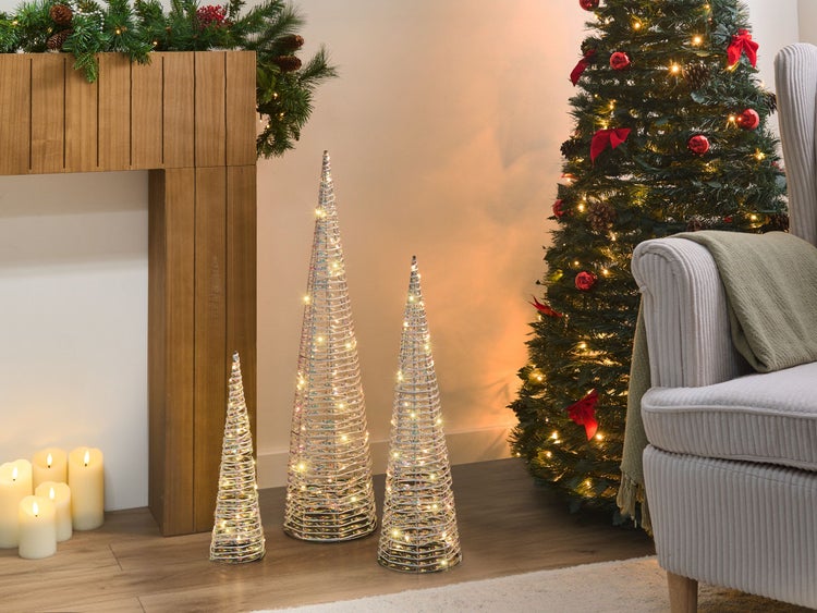 Dekoratives Wohnzimmer mit beleuchteten Dekobäumen, Weihnachtsbaum und Kamin