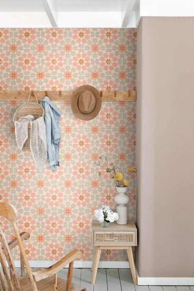 Vliestapete mit geometrischem, floralem Muster im Fliesen-Stil an einer Wand mit Garderobe aus Holz und Beistelltisch.
