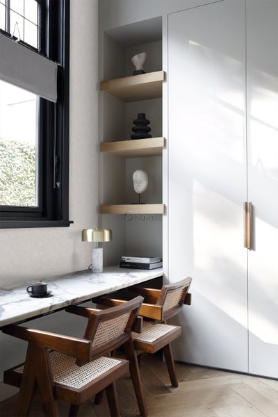 Innenraumszene mit einem Schreibtisch aus Marmor, Holzstühlen und Regalen