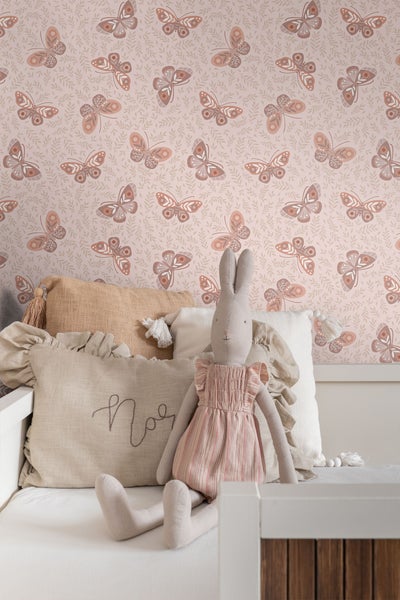 Kindertapete mit Schmetterlingsmuster und Dekokissen auf einer Bank
