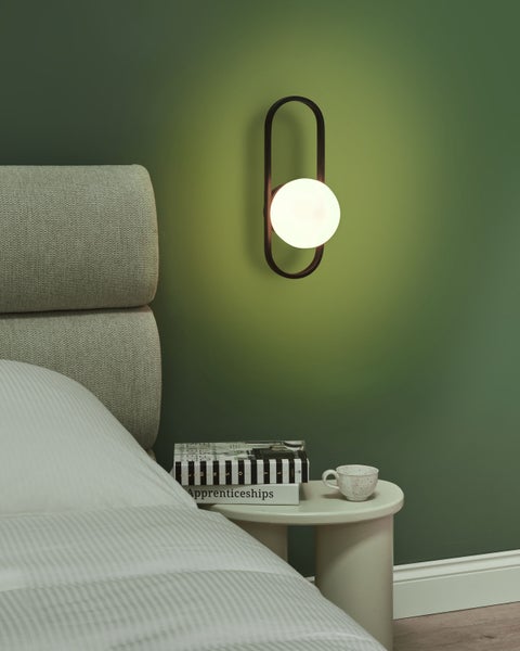 Wandleuchte mit schwarzem Rahmen und runder, weißer Glühbirne