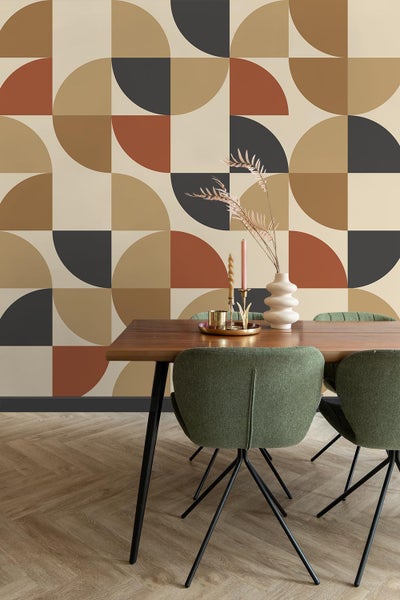 Esszimmer mit modernem geometrischem Tapetenmuster, Holztisch und grünen Stühlen.