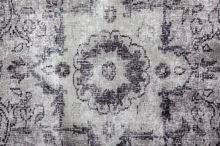 Nahaufnahme eines Teppichs im Vintage-Stil mit einem abgenutzten Medaillon-Muster.