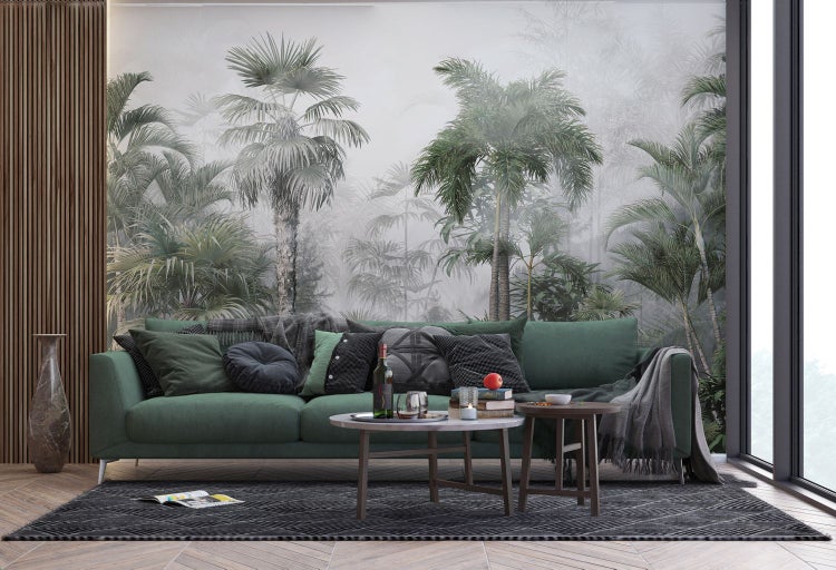 Wohnzimmer mit grüner Couch, Couchtisch und Wandtapete mit Palmenmotiv.