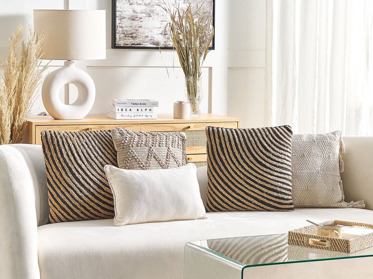Wohnzimmerdekoration mit Kissen auf einem Sofa, einer Lampe und einem Tisch.