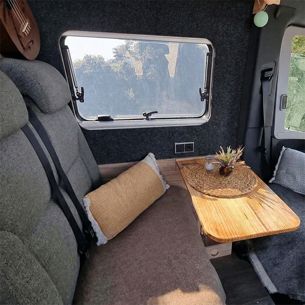 Innenraum eines Wohnmobils mit Sitzecke, Tisch und Fenster