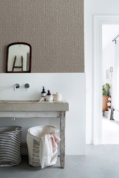 Detailaufnahme eines Badezimmers mit Stricktapete, Waschbecken und Wäschekörben.