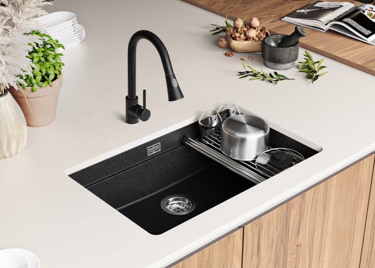 Küchenspüle aus Granit mit schwarzer Armatur in moderner Küchenumgebung.