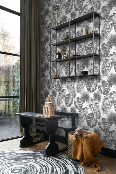Dekoratives Interieur mit einer schwarzen Bank, einem Regal und einer gemusterten Tapete.