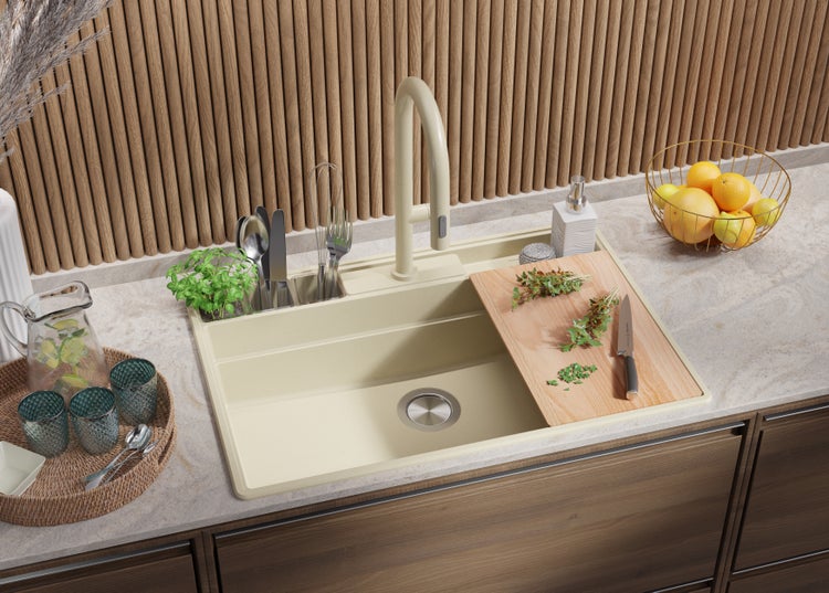 Küchenspüle mit Armatur, Schneidebrett, Geschirr und Lebensmitteln auf einer Küchentheke.