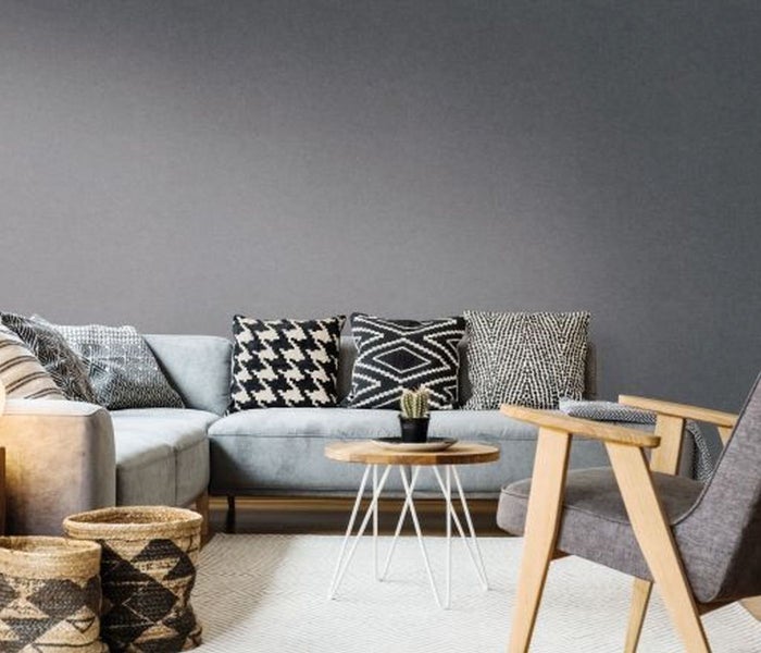 Wohnzimmer mit Sofa, Sessel, Couchtisch und dekorativen Körben