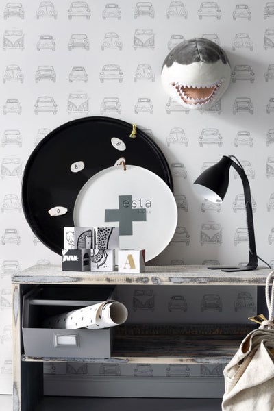 Dekoratives Interieur mit Schreibtisch, Lampe, Dekorationsgegenständen und Tapete mit Automotiv