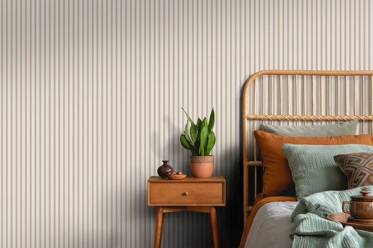 Schlafzimmer mit gestreifter Tapete, Rattanbett und Nachttisch mit Topfpflanze