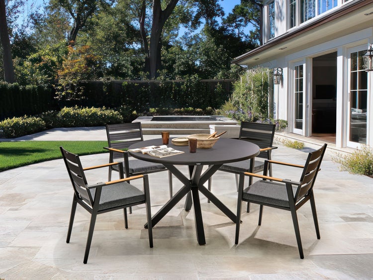 Gartenszene mit runder Tischgruppe und Stühlen auf einer Terrasse