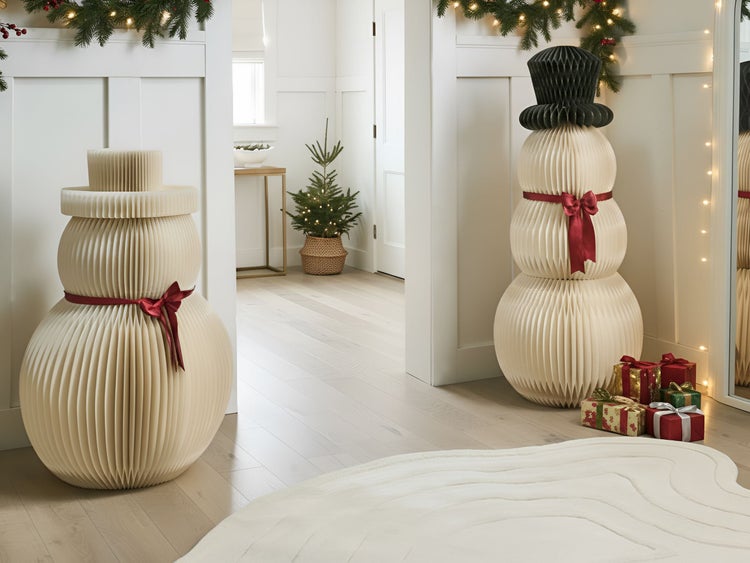 Weihnachtliche Innendekoration mit Papier-Schneemännern, Geschenken und Lichterketten