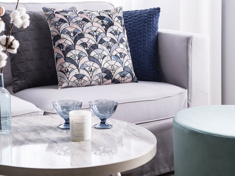 Drei Pendelleuchten aus Glas und Metall über einem Esstisch mit Geschirr und Dekoration