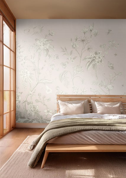 Helles Schlafzimmer mit floraler Tapete und Holzbett