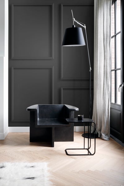 Wohnzimmer mit Sessel, Stehlampe und Beistelltisch