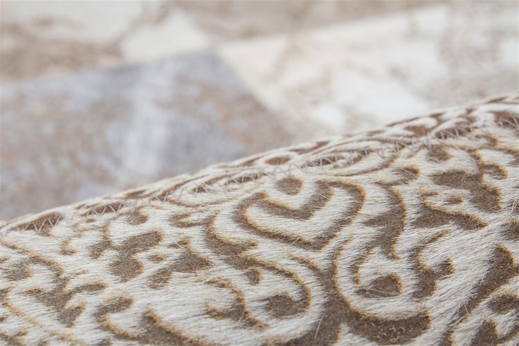 Detailaufnahme eines Patchwork-Teppichs aus Kuhfell mit eingearbeitetem Ornament-Muster.