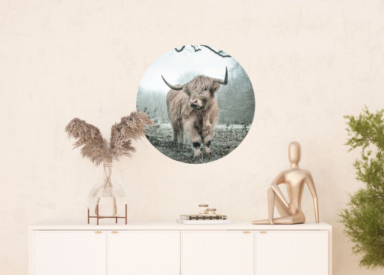 Wanddekoration mit schottischem Hochlandrind im runden Ausschnitt über einem Sideboard