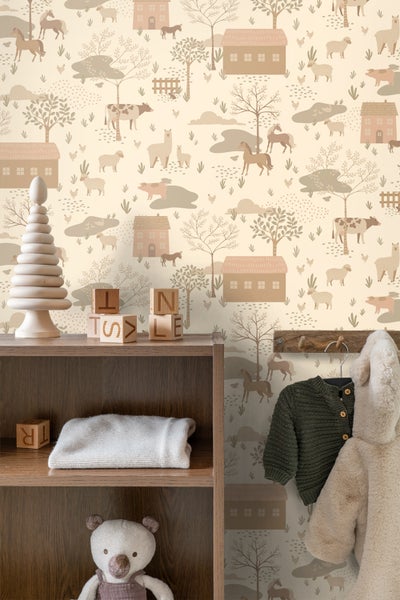 Kinderzimmer mit einer Tapete, die Bauernhoftiere, Häuser und Bäume darstellt, sowie ein Holzregal mit Spielsachen und Kinderkleidung.