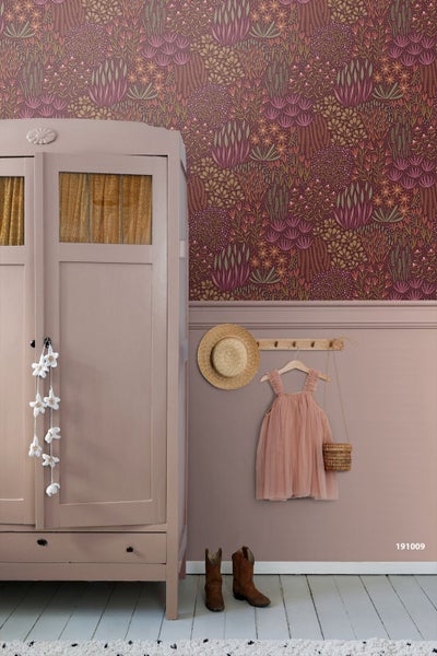 Wandgestaltung mit einer Vliestapete mit floralem Muster oben und einer rosa Wand unten. Kleiderschrank und Garderobenleiste ergänzen die Szene.