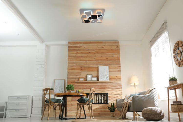 Heller Wohnraum mit Esstisch, Stühlen, Sofa und moderner Deckenleuchte