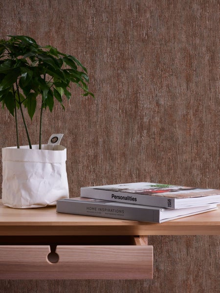 Nahaufnahme einer Wand mit Holzstruktur-Tapete, dekoriert mit einer Pflanze, Büchern und einem Tisch