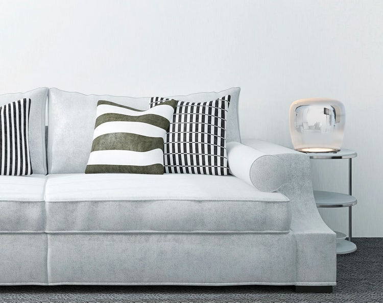 Modernes Wohnzimmer mit Sofa, Kissen und Tischlampe