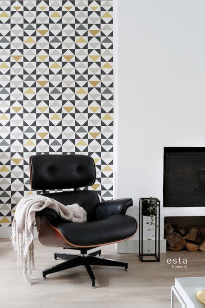 Wohnzimmer mit gemusterter Tapete, Sessel, Pflanze und Kaminholz