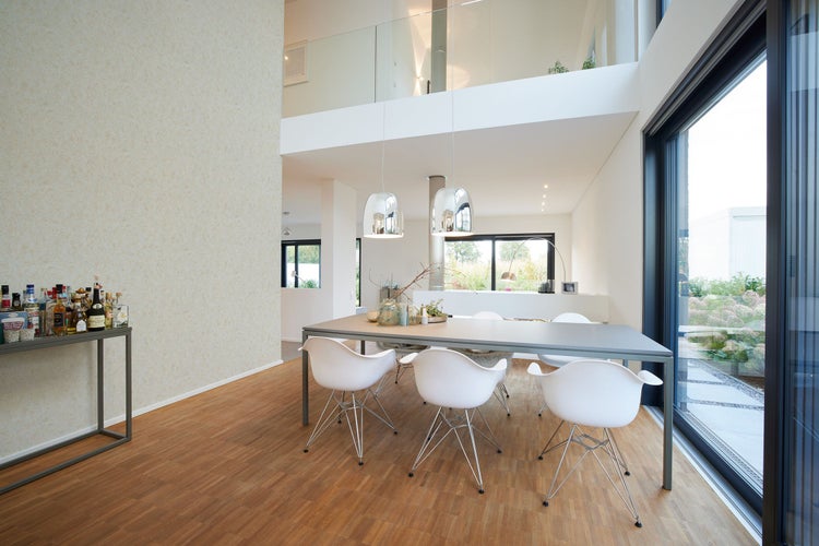 Dekoratives Interieur mit gemusterter Tapete und dunkler Holzkommode