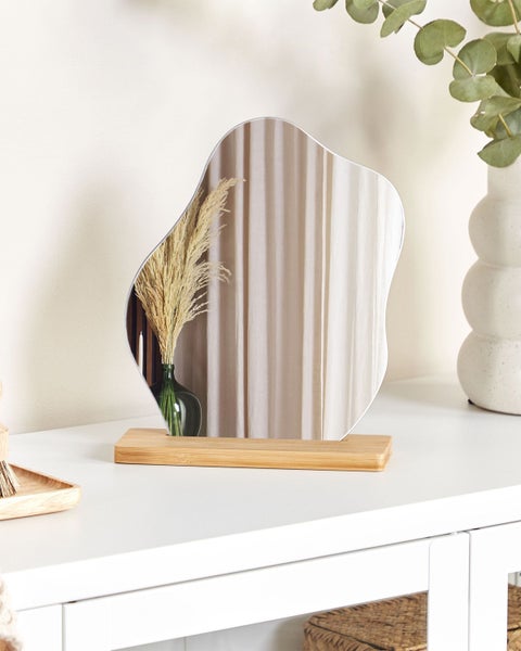 Dekorativer Tischspiegel mit Holzfuß auf einem Tisch