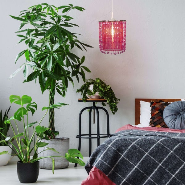 Schlafzimmer mit Bett, Zimmerpflanzen und dekorativer Hängelampe