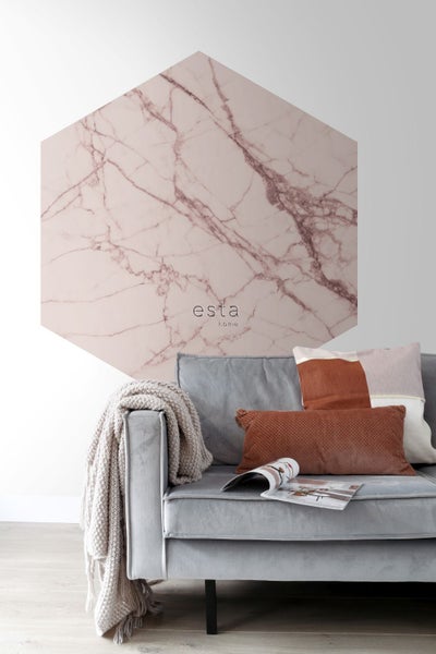 Wohnzimmer mit grauer Couch, Kissen und sechseckiger Wanddekoration im Marmorstil