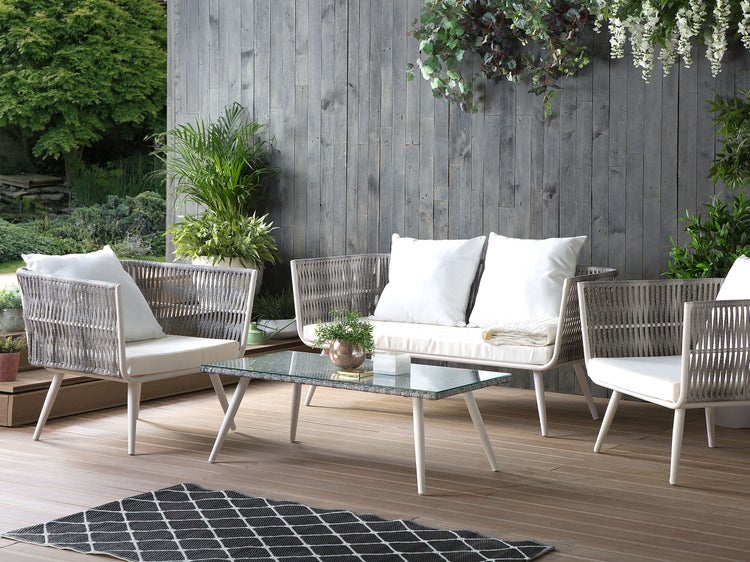 Gartenmöbel-Set mit Sofa, Stühlen und Tisch auf einer Terrasse