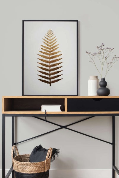 Gerahmtes Bild mit Farnblatt-Motiv über einem Konsolentisch aus Holz und Metall in einem modern eingerichteten Raum.