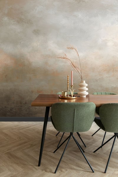 Esszimmer mit Holztisch, grünen Stühlen, Dekoration und gemusterter Wand