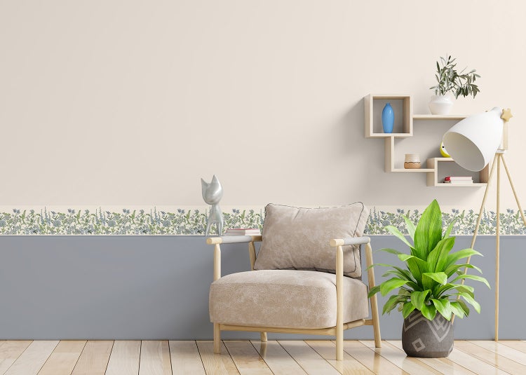 Selbstklebende Tapetenbordüre mit floralem Wildblumenmuster in einem hellen Wohnzimmer mit Sessel, Pflanze und Holzboden.