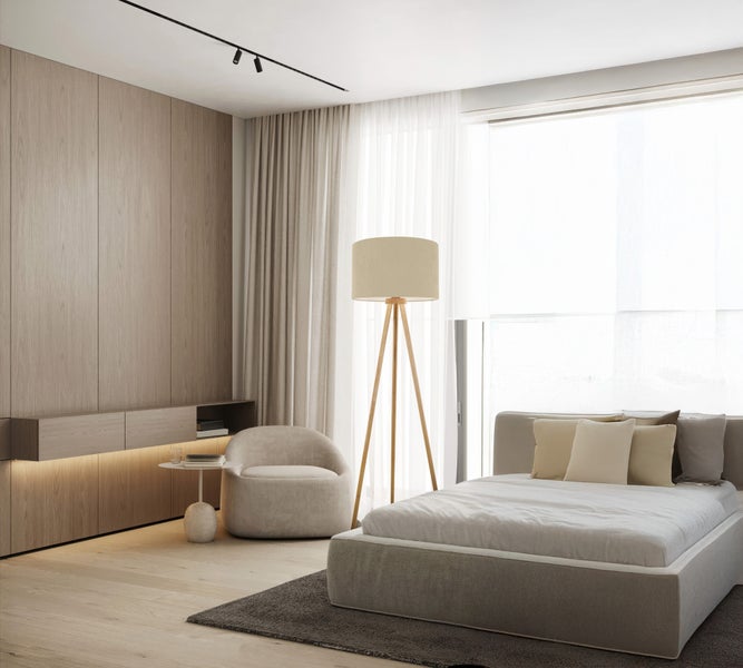 Schlafzimmer mit Bett, Sessel und Holzverkleidung