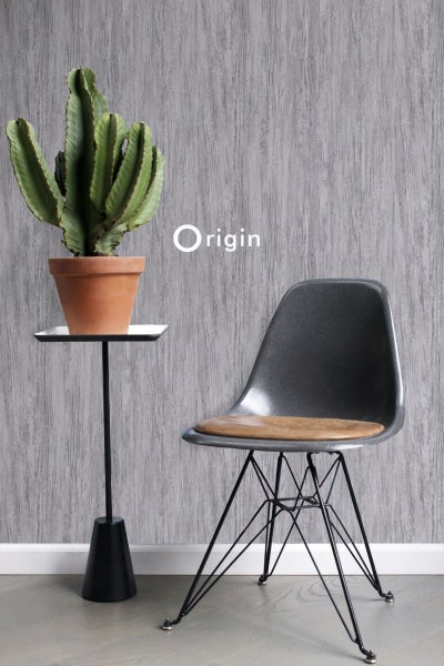 Dekorative Szene mit Kaktus auf einem Beistelltisch und einem Stuhl vor einer gemusterten Wand