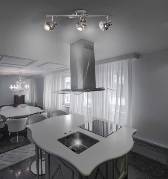 Innenaufnahme einer modernen Küche mit Kochinsel, Dunstabzugshaube und Deckenleuchte.