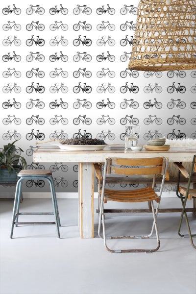 Wohnraum mit Fahrradtapete, Esstisch, Stühlen und Pendelleuchte