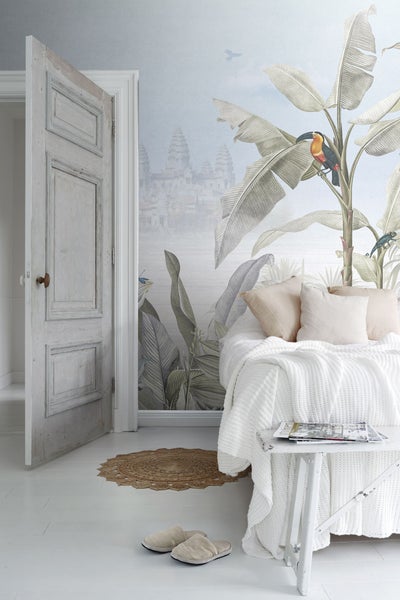 Einladendes Schlafzimmer mit Dschungel-Tapete, rustikaler Tür und Strickdecke